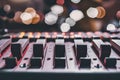 Audio console mixer close up with faders up, bokeh background