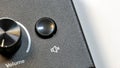 Audio device volume knob and mute button icon close up on black control panel, circular dial with textured finish and speaker with Royalty Free Stock Photo