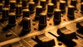Audio Mixing Console Close-Up: Knobs, Faders, and Red Indicator Lights in Warm Tone Royalty Free Stock Photo