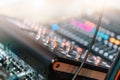 audio mixing console in music production studio, focus on control knobs and cables, with blurred background enhancing Royalty Free Stock Photo