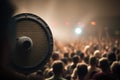 audio speaker in the middle of a stage, with a blurred view of the audience behind