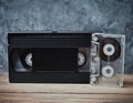 Audio and video cassette close-up on a wooden shelf against a gray concrete wall. Retro technology for listening to music Royalty Free Stock Photo