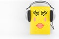 Audiobook on white background. Headphones put over yellow hardback book, empty cover, copy space for ad text. Distance Royalty Free Stock Photo