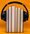 Audiobooks concept. Headphones put over book against orange background