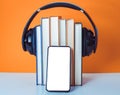 Audiobooks concept. Headphones put over book on orange and white background. Smart phone. Mobile phone