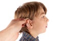 Audiologis inserting a hearing aid in a young boy patient`s ear. Royalty Free Stock Photo