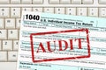 Audit message with US federal 1040 tax return form on a keyboard