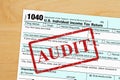 Audit message with US federal 1040 tax return form on a desk