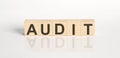 AUDIT word from wooden blocks on the white desk Royalty Free Stock Photo
