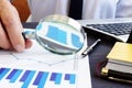 Auditor with magnifying glass checking financial report. Royalty Free Stock Photo