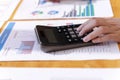 An auditor using a calculator for calculating with financial report on wooden table.presas  calculator. Royalty Free Stock Photo