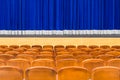 The auditorium in the theater. Blue curtain on the stage. Blue-brown chair. Room without people Royalty Free Stock Photo