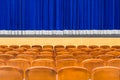 The auditorium in the theater. Blue curtain on the stage. Blue-brown chair. Room without people