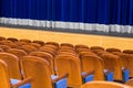 The auditorium in the theater. Blue curtain on the stage. Blue-brown chair. Room without people Royalty Free Stock Photo