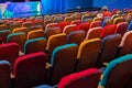 The auditorium in the theater. Multicolored spectator chairs. One person in the audience Royalty Free Stock Photo
