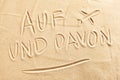 Auf und Davon with airplane on beach sand Royalty Free Stock Photo