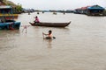 Aug : 29 : 2018 - SIEM REAP, CAMBODIA - Mother and son on the boat with boy use basin as a boat at in Tonle Sap Lake..