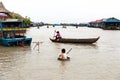 Aug : 29 : 2018 - SIEM REAP, CAMBODIA - Mother and son on the boat with boy use basin as a boat at in Tonle Sap Lake.