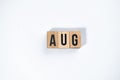 ` AUG ` text made of wooden cube on White background