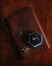 Vertical shot of compass notebook with ring box on it on a wooden table