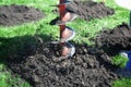 Auger drilling holes in the yard.