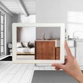 Augmented reality concept. Hand holding tablet with AR application used to simulate furniture products in custom architecture