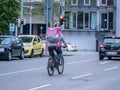 Augsburg, Germany - May 5, 2019: Delivery man on bike with food box in purple colour