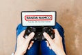 August 8, 2023, Brazil. A person playing on a joystick and the Bandai Namco Entertainment logo