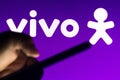 August 6, 2021, Brazil. In this photo illustration a silhouette of a hand holding a mobile phone is seen in front of Vivo logo
