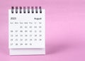 The August 2023 desk calendar on pink color background