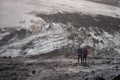 August of 2019. Iceland. Two tourist on background of Black Volcanic Iceland Landscape At Fimmvorduhals Hiking Trail