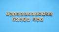 International Youth Day, minimalistic banner with the inscription in wooden letters on a blue background