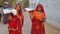 Indian women offer milk or sacred food by hand to the idol of the god. Hinduism and festival concept