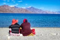 August 2018, Lake Pangong,Kashmir, India. two tourists sitting beside lake pangong during the day in front of blue waters and