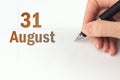 August 31st . Day 31 of month, Calendar date. The hand holds a black pen and writes the calendar date. Summer month, day of the