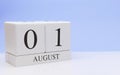 August 01st. Day 1 of month, daily calendar on white table with reflection, with light blue background. Summer time, empty space