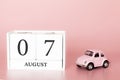 August 07th. Day 7 of month. Calendar cube on modern pink background with car