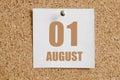 august 01. 01th day of the month, calendar date.White calendar sheet attached to brown cork board.Summer month, day of