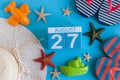 August 27th. Image of August 27 calendar with summer beach accessories and traveler outfit on background. Summer day