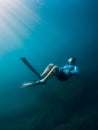 August 07, 2021. Varna, Bulgaria. Men free diver with fins in blue sea and sun rays. Freediving underwater in transparent water