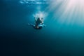 August 07, 2021. Varna, Bulgaria. Men free diver with fins in blue sea and sun rays. Freediving underwater in transparent water