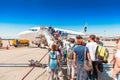 People stay in line boarding to an airplane of UTair airlines