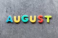 August word written with colorful letters on grey granite stone background