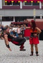 02 August 2019 - Young woman pointing up and man suspended in the air on a street circus performance during a medieval event