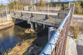 A canal in an industrial area overgrown bridge fence