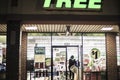 Dollar Tree retail store at night lady wearing face mask exits Royalty Free Stock Photo