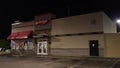 Pan of Hardees fast food restaurant at night side view background traffic