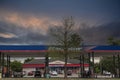 Raceway gas station and building with people and cars