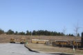 Row of parked New and old yellow school buses parked in a row distant view Royalty Free Stock Photo