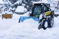 Auron, France 01.01.2021 A harvesting tractor cleans snow in a ski resort on the road in a heavy snowfall. Mountain